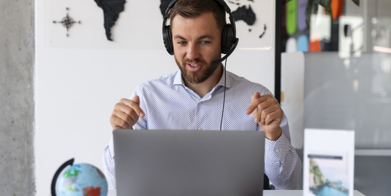 Pracownik rozmawia online przy komputerze podczas koordynacji zlecenia transportowego